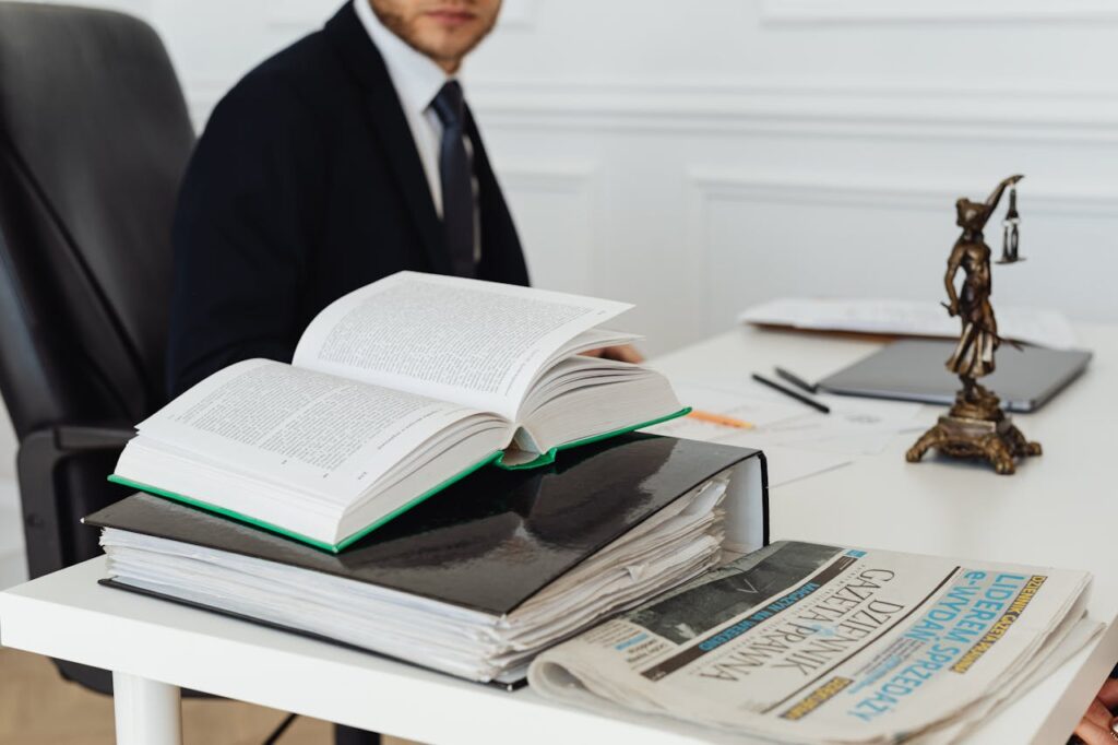 A lawyer sitting at a desk with legal books, documents, and a newspaper, embodying professionalism.